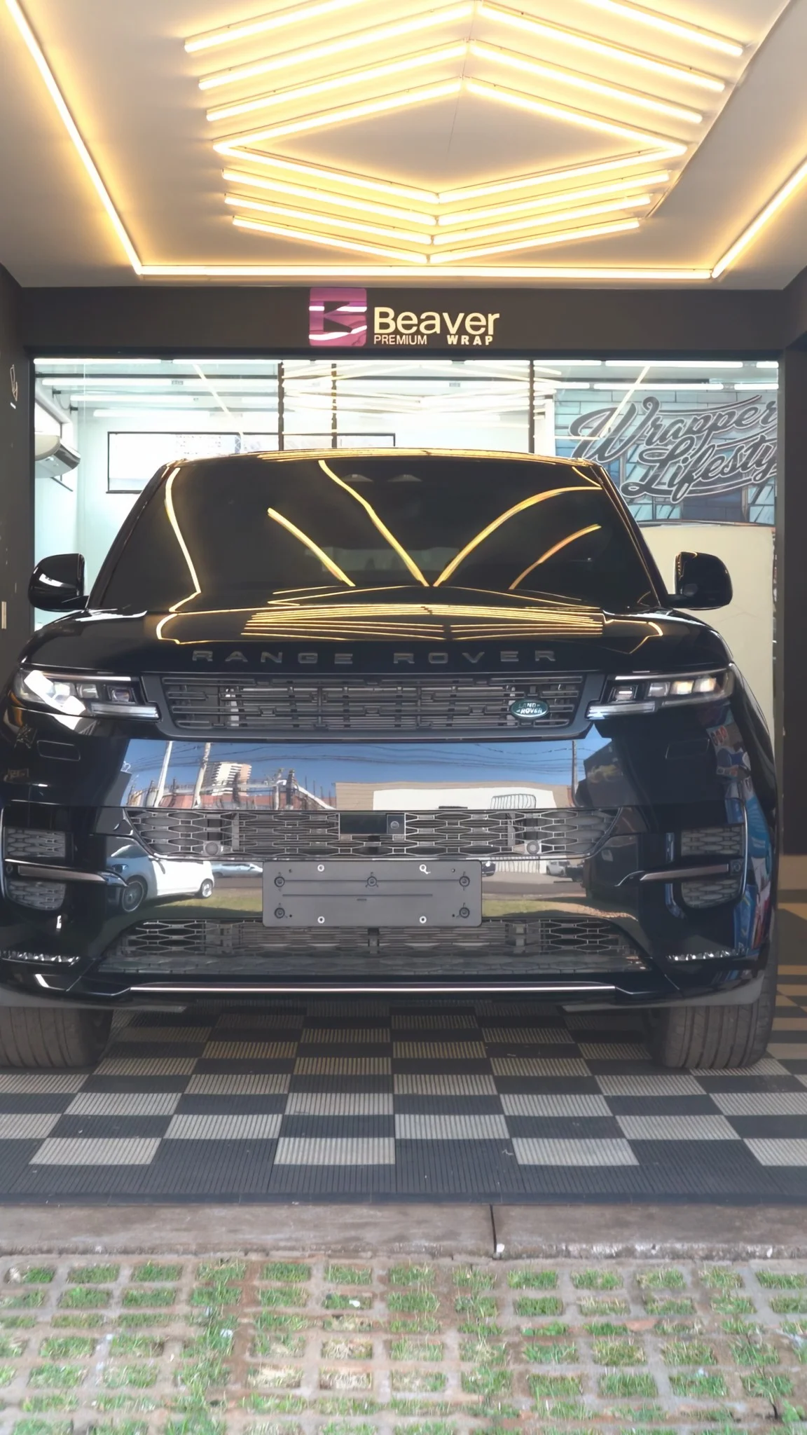 Range Rover preto com acabamento premium na frente da loja